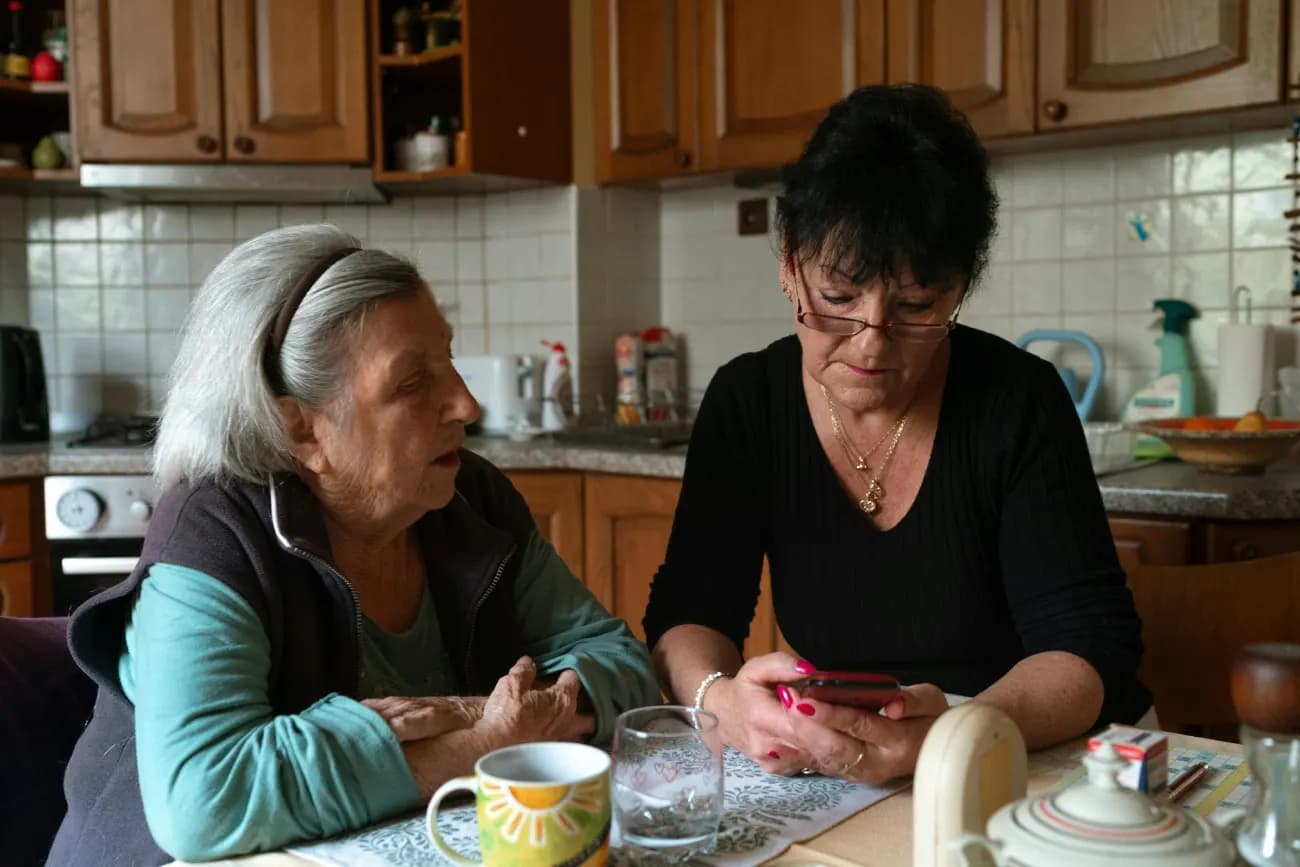 Două femei stau de vorbă la masa din bucătărie